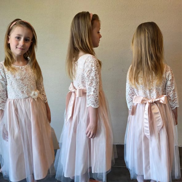 Alt tekst:
Luxe blush roze meisjesjurk met kanten details, tule rok en satijnen strik uit de Petite Occasion Dresses collectie van Jacobsz Atelier.