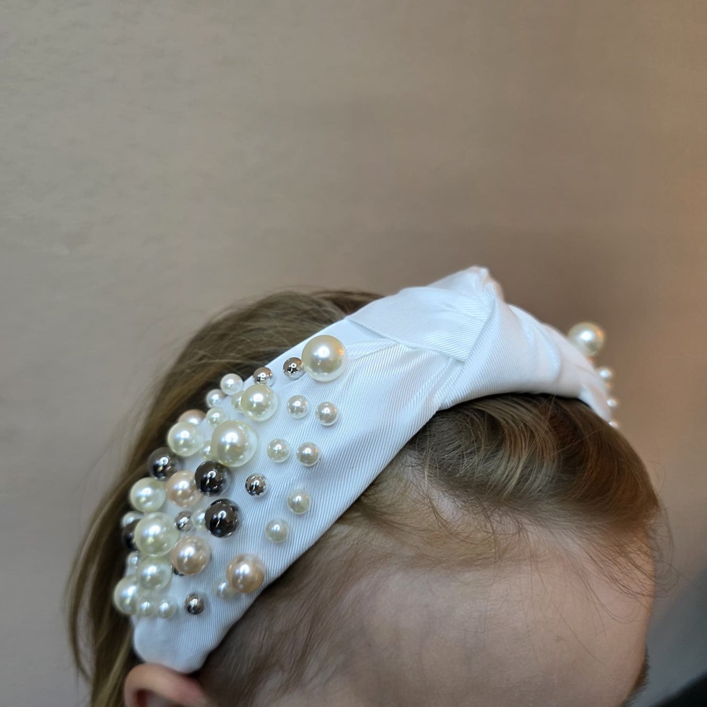 Een luxehaarband van Jacobsz Atelier met elegante satijnen afwerking en verfijnde pareldetails. De Pearl Deluxe LUX Headband geeft iedere look een chique en vrouwelijke uitstraling en is perfect voor feestjes, communies, bruiloften en andere speciale gelegenheden.
